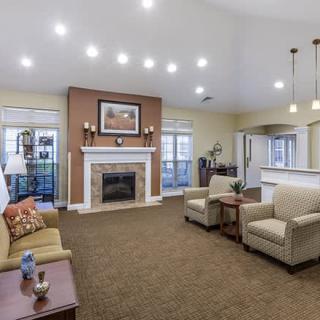 A modern living room with a fireplace, sofas, and ceiling lights creating a cozy ambiance.