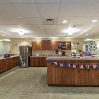 A spacious office kitchen with wooden cabinets, countertops, and festive decorations.