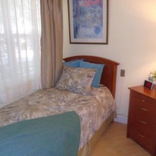 A cozy bedroom with a single bed and wooden furniture.