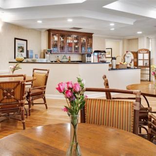 A cozy dining area with wooden furniture and a vase of flowers on the table.