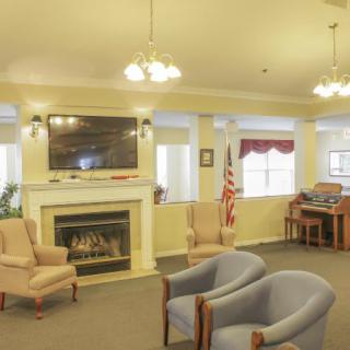A cozy living room with a fireplace, television, seating area, and decorative lighting.