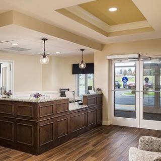 A modern reception area with wooden flooring and stylish lighting.