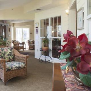 A cozy living room featuring wicker furniture and a floral arrangement.