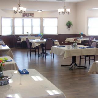 A spacious and well-lit dining area with neatly arranged tables and chairs.