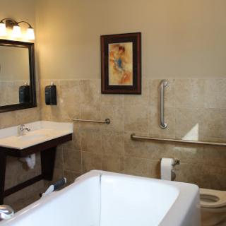 A well-designed bathroom featuring a bathtub, sink, and accessibility options.