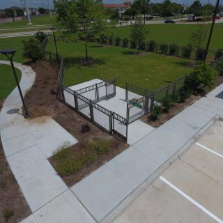 A neatly landscaped outdoor area with pathways and fenced enclosures.