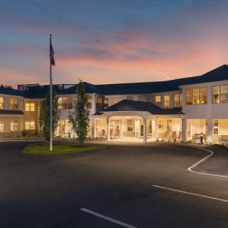 A modern building with a flagpole at sunset.