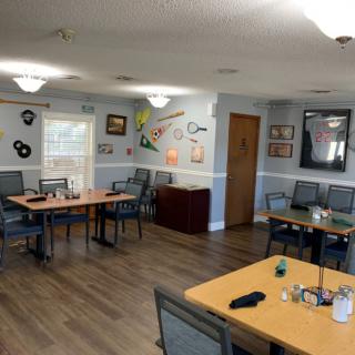 A cozy dining area featuring several tables and chairs, decorated with various artworks and memorabilia on the walls.