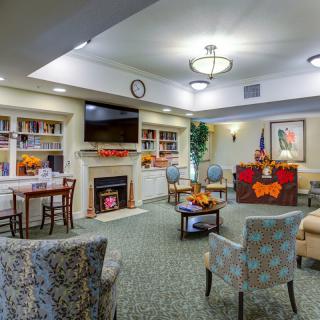 A cozy living room with comfortable seating, a fireplace, and a television, adorned with warm decor.