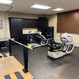 A well-equipped physical therapy room featuring various rehabilitation machines.