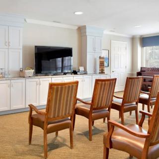 An indoor seating area with wooden chairs facing a television.