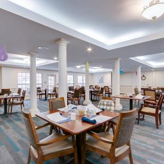 A spacious and elegantly designed dining area with neatly arranged tables and chairs.