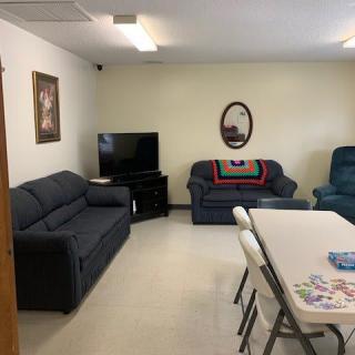 A cozy living room with sofas, a television, and a table with chairs.