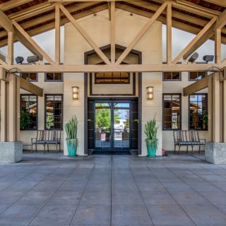 A building entrance with plants and outdoor seating.