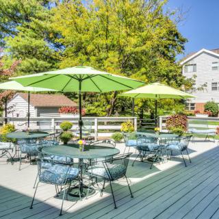 Outdoor patio area with tables, chairs, and umbrellas on a sunny day.
