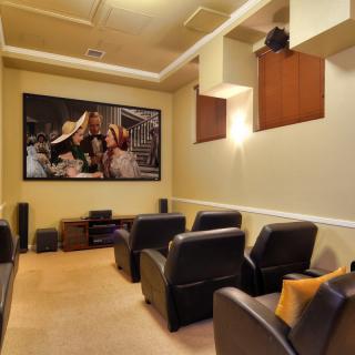 A cozy home theater setup with comfortable seating and a large projector screen.