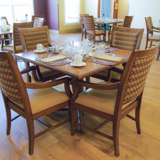 A restaurant dining area with a neatly set table including glasses and cups.