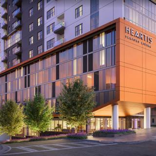 A modern urban building with sleek architecture and surrounding trees.