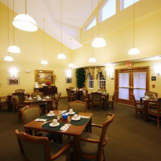 A cozy dining area with neatly set tables and warm lighting.