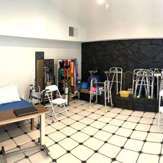A physical therapy clinic with various rehabilitation equipment, including walkers and crutches.