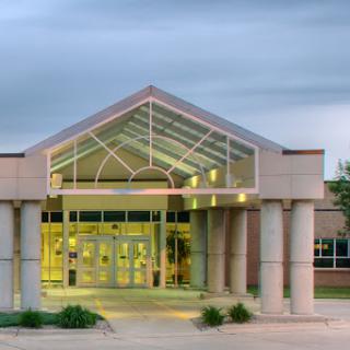 A modern educational building showcasing a glass entrance and sleek architectural design.