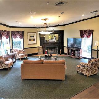 A cozy living room with sofas, armchairs, a television, and a fireplace.