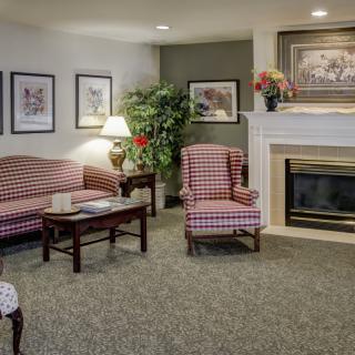 A cozy living room with patterned furniture, a fireplace, and decorative elements.