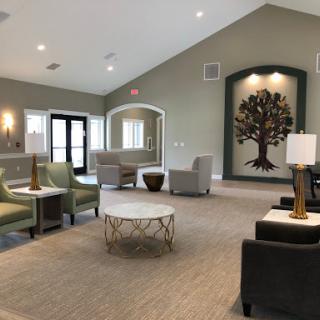 A modern lounge area featuring comfortable seating and a decorative tree art piece.