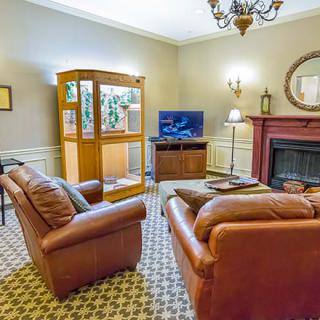 A cozy living room with sofas, a television, and a fireplace.