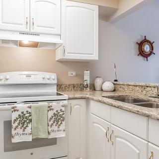 A modern kitchen with white cabinets and a granite countertop.