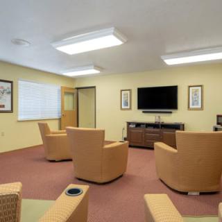 A modern waiting room with comfortable seating and a television.