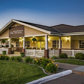A cozy restaurant building with a welcoming porch, set against the evening sky.