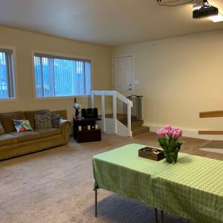 A cozy living room with a sofa, a table adorned with flowers, and carpeted flooring.