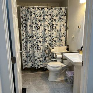 A clean and organized bathroom with a patterned shower curtain.