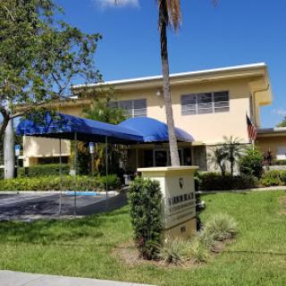 A well-maintained building with a blue canopy and lush landscaping.