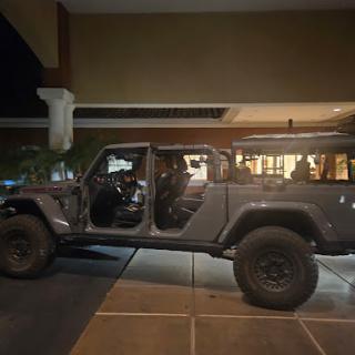 A gray Jeep parked in a well-lit area at night, showcasing its spacious interior.