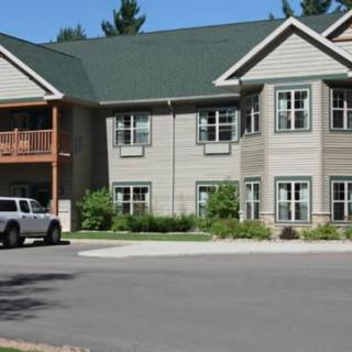 A two-story residential apartment building with a parking lot in front.