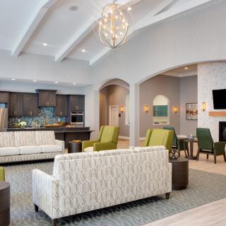 A modern and cozy living room with elegant furniture and a stylish chandelier.