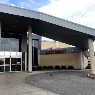 A modern commercial building entrance featuring a distinctive roof design.