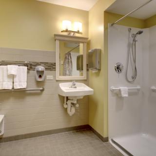 A well-equipped bathroom featuring a shower, sink, and essential amenities.