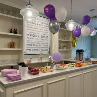 A festive setup for a celebration, featuring colorful balloons and a variety of snacks.