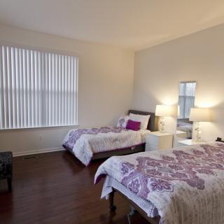 A cozy bedroom with two single beds and soft lighting.