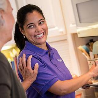A friendly interaction between two women in a kitchen setting.