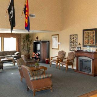 A spacious living room with comfortable seating, a decorative fireplace, and flags on display.