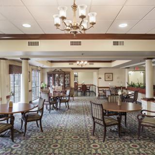 A spacious dining area with elegant furniture and a chandelier.