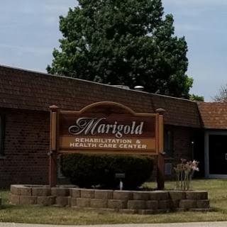 Martgold Health and Rehabilitation Center sign in front of the building surrounded by greenery.