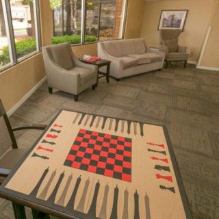 A cozy living room setup featuring a table with a combined checkers and backgammon board, surrounded by sofas and chairs.