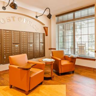 A cozy post office interior with mailboxes and a comfortable seating area.