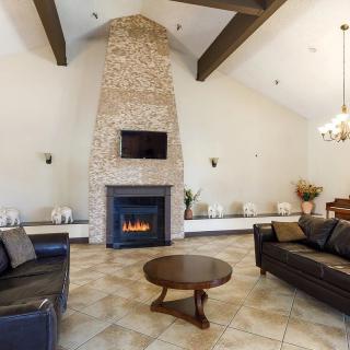 A cozy living room with a stone fireplace and modern furnishings.