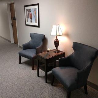A hallway with two chairs, a small table, and a lamp.